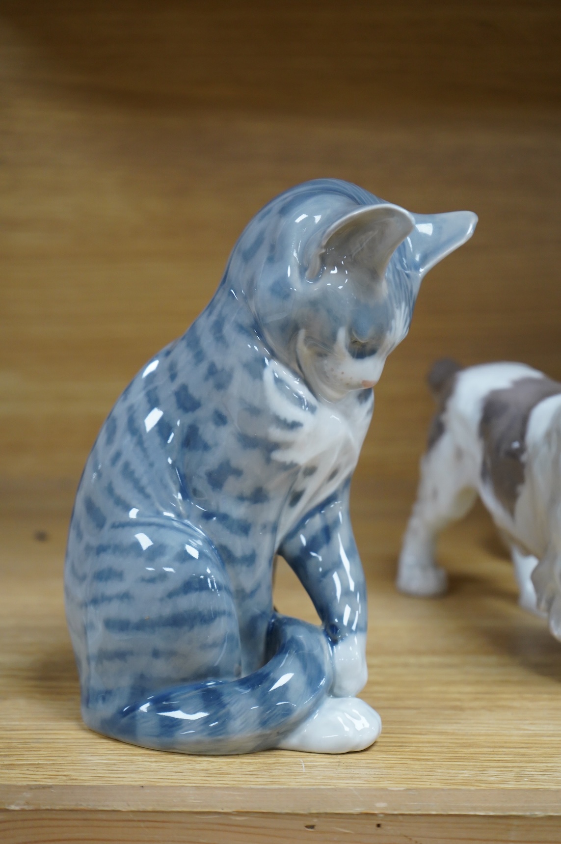 A Royal Copenhagen figure, 'The Sandman', Number 1129, a similar cat, number 340, a B&G spaniel and a Danish lion, tallest 18.5cm
